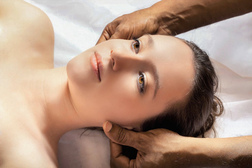 A calming spa massage session with a young woman receiving a relaxing head massage.